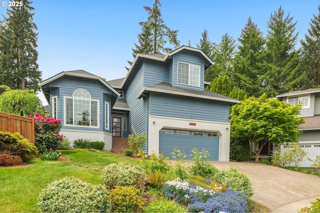 view of front of house featuring a garage, driveway, and roof with shingles