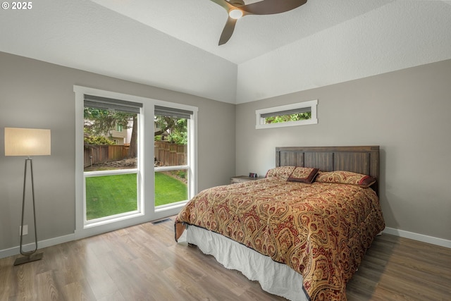 bedroom with wood finished floors, baseboards, vaulted ceiling, and a ceiling fan