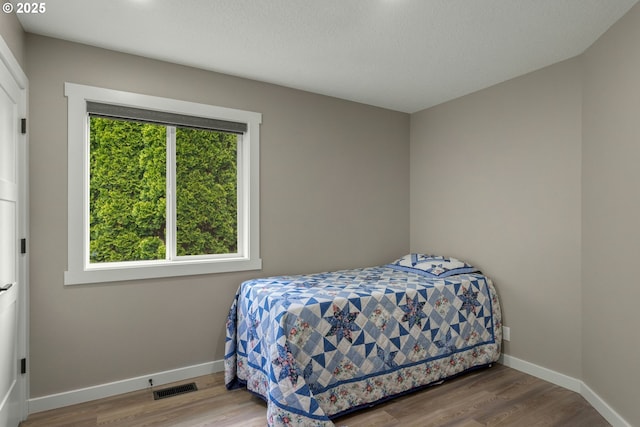 bedroom with wood finished floors and baseboards