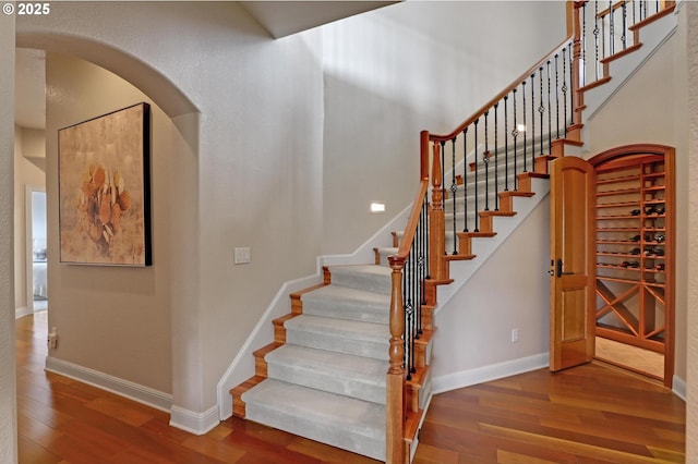8333 NW Hazeltine St, Portland, OR 97229 - stairway with wood finished floors, arched walkways, and baseboards