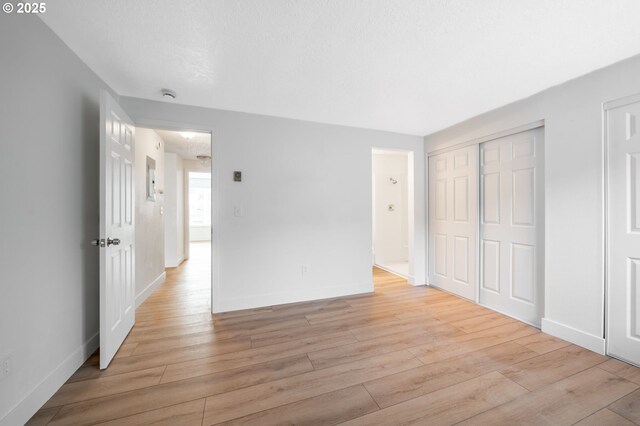 unfurnished bedroom with baseboards and light wood-type flooring