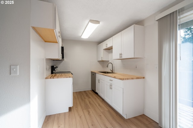 kitchen with a sink, light wood finished floors, and butcher block counters