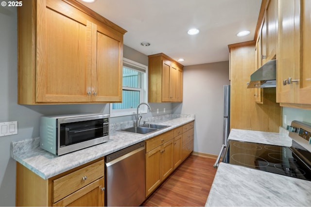 7915 SW Fanno Creek Dr Unit 1, Portland, OR 97224 - kitchen featuring stainless steel appliances, a sink, under cabinet range hood, light countertops, and light wood finished floors