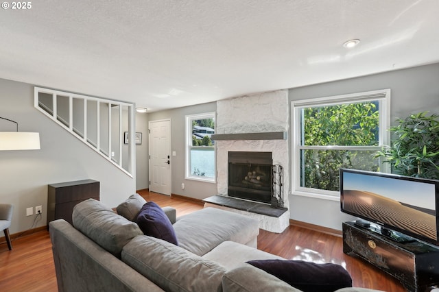 7915 SW Fanno Creek Dr Unit 1, Portland, OR 97224 - living area featuring stairs, a large fireplace, baseboards, and wood finished floors