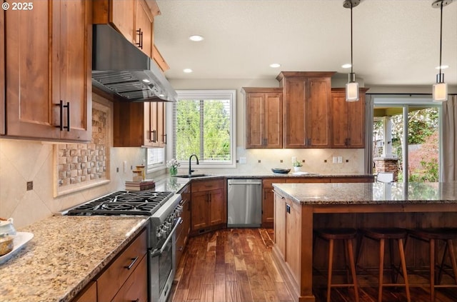 kitchen featuring stainless steel appliances, a sink, dark wood-style flooring, light stone countertops, and under cabinet range hood