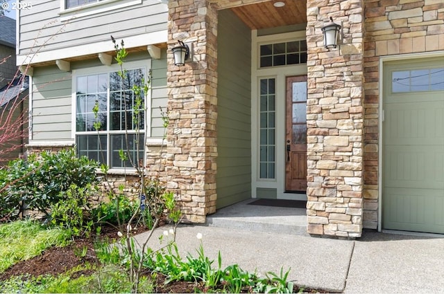 property entrance featuring stone siding and a garage