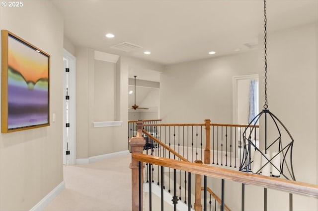 corridor featuring recessed lighting, carpet, baseboards, and an upstairs landing