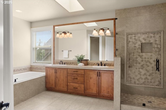 bathroom with a shower stall, a garden tub, a sink, and a skylight