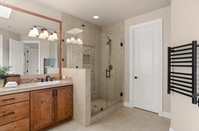 bathroom with a shower stall, radiator heating unit, tile patterned flooring, vanity, and baseboards