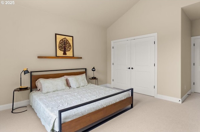 bedroom with lofted ceiling, a closet, carpet flooring, and baseboards