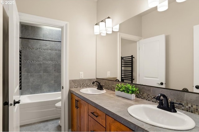 bathroom with tile patterned flooring, a sink, double vanity, and toilet