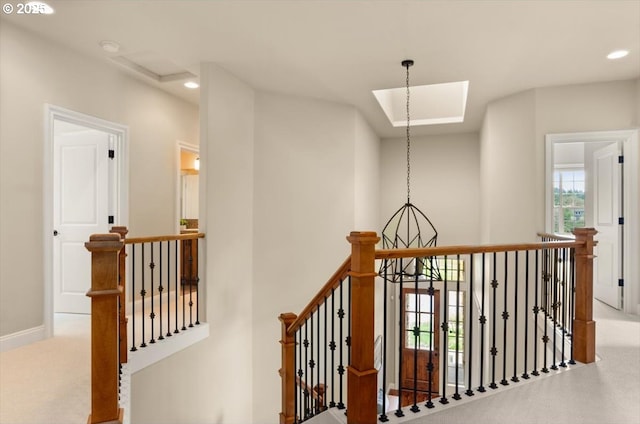 hallway featuring recessed lighting, carpet flooring, baseboards, and an upstairs landing