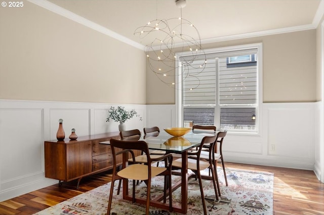 dining room with a notable chandelier, a decorative wall, and crown molding