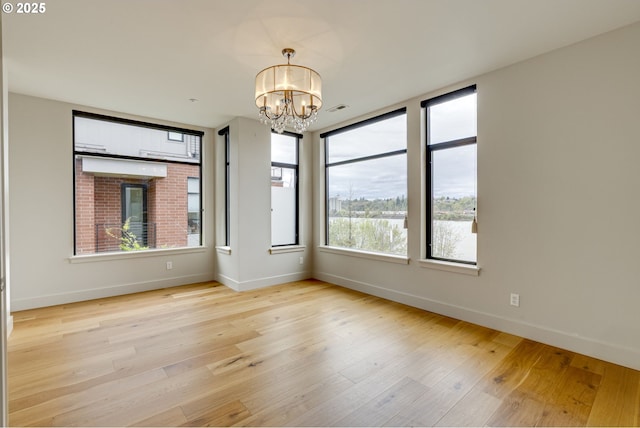 1716 NW Riverscape St, Portland, OR 97209 - spare room with baseboards, a chandelier, and wood finished floors