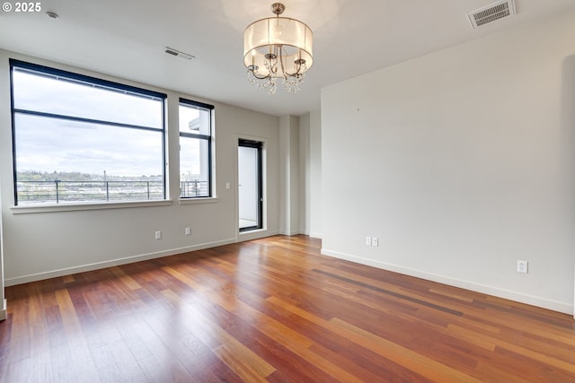 1716 NW Riverscape St, Portland, OR 97209 - spare room featuring visible vents, baseboards, a chandelier, and wood finished floors