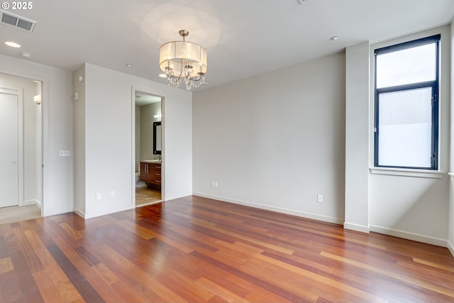 1716 NW Riverscape St, Portland, OR 97209 - spare room with visible vents, baseboards, a notable chandelier, recessed lighting, and wood finished floors