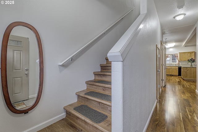 stairway with baseboards and wood finished floors