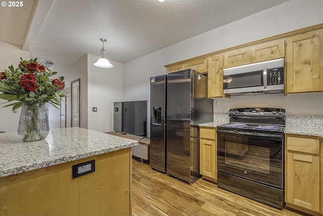 kitchen featuring black appliances, light wood-style flooring, light brown cabinetry, pendant lighting, and light stone counters