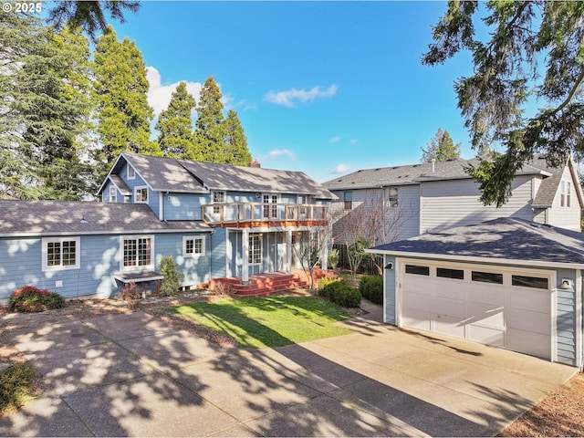 view of front of house with a balcony, a garage, and a front lawn