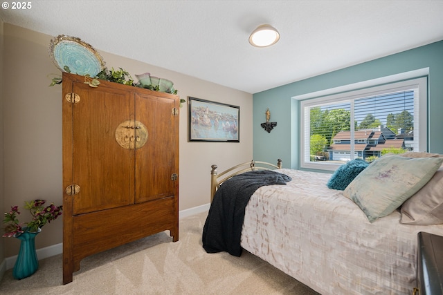 bedroom with baseboards and light colored carpet