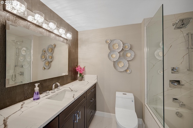 full bath featuring vanity, marble finish floor, toilet, baseboards, and washtub / shower combination