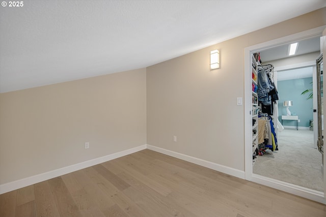 bonus room featuring baseboards and light wood-style floors