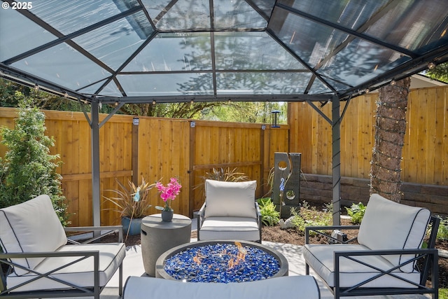 view of patio with a gazebo, an outdoor living space with a fire pit, and fence