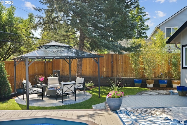 view of pool featuring a gazebo, a wooden deck, a fenced backyard, and a patio area
