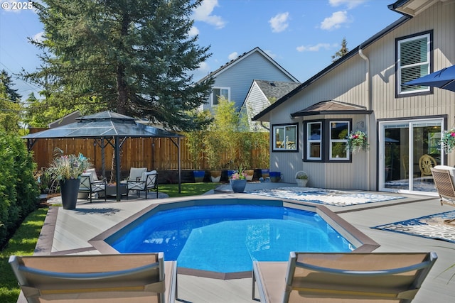 view of swimming pool featuring a fenced in pool, fence, a wooden deck, and a patio