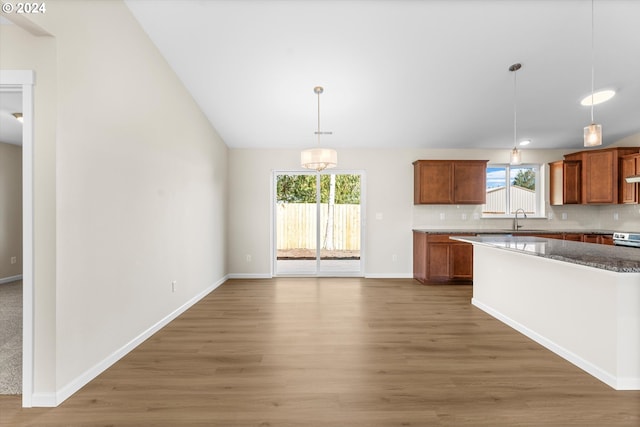11480 Fern Way, Nehalem, OR 97131 - kitchen featuring decorative backsplash, light wood-style flooring, hanging light fixtures, and brown cabinets