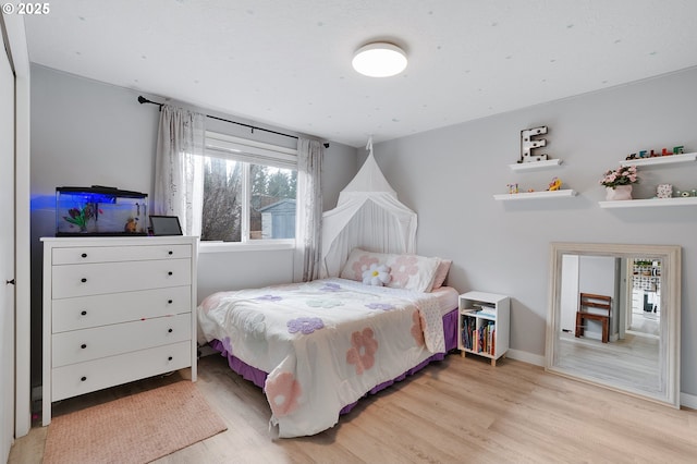 bedroom with light wood-style flooring and baseboards