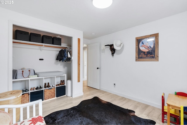 bedroom featuring a closet, baseboards, and wood finished floors