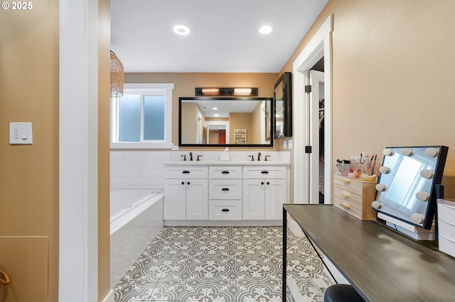 bathroom featuring a garden tub, double vanity, recessed lighting, a sink, and tile patterned flooring