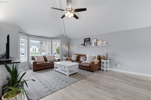 living area featuring lofted ceiling, ceiling fan, baseboards, and wood finished floors