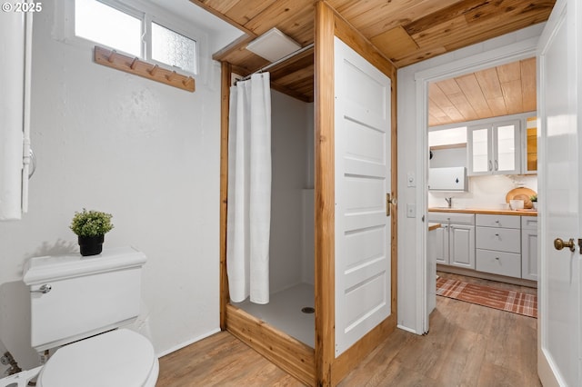 full bathroom featuring a shower stall, toilet, wooden ceiling, wood finished floors, and vanity