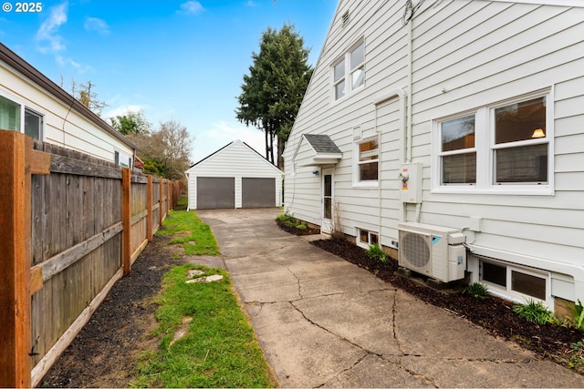 view of side of home with an outdoor structure, ac unit, fence, and a detached garage