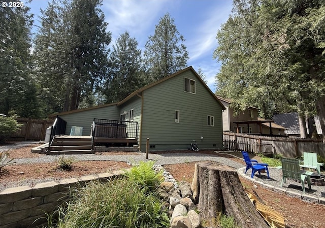 65121 E Lupine Dr, Rhododendron, OR 97049 - view of side of property featuring crawl space, a deck, a fenced backyard, and a fire pit
