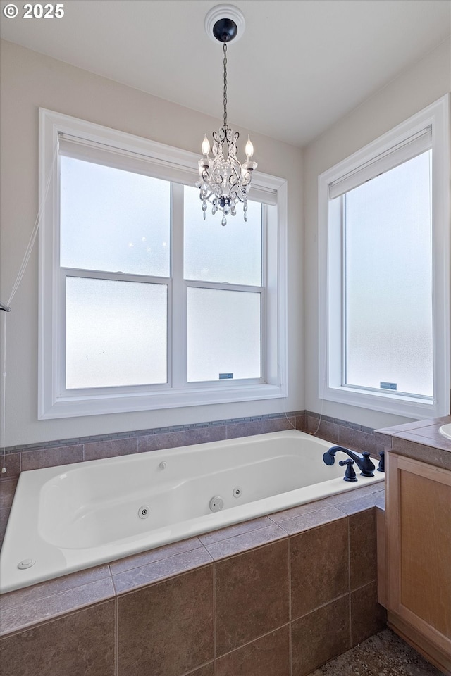 5779 NE Voyage Way, Lincoln City, OR 97367 - bathroom with a relaxing tiled tub, a healthy amount of sunlight, and an inviting chandelier