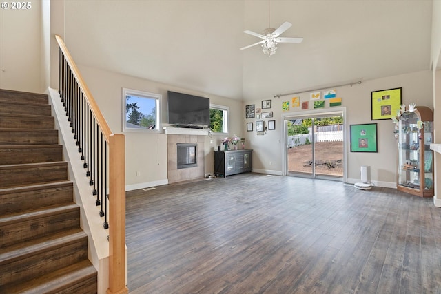5779 NE Voyage Way, Lincoln City, OR 97367 - unfurnished living room with dark hardwood / wood-style flooring, ceiling fan, a fireplace, and a towering ceiling