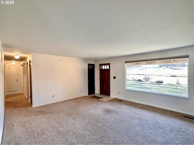 carpeted empty room featuring a textured ceiling