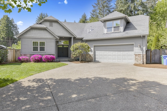 view of front facade featuring a front lawn, fence, stone siding, and concrete driveway