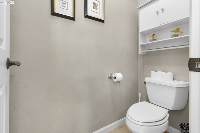 bathroom with baseboards and toilet