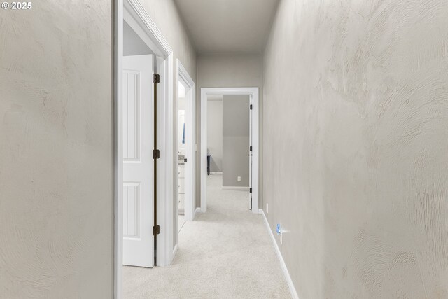 corridor with carpet flooring and baseboards