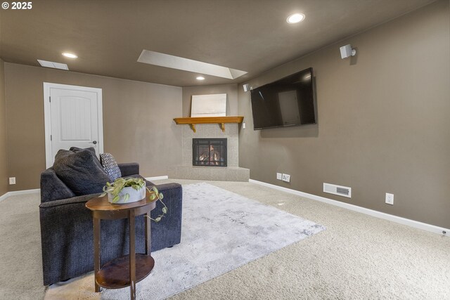 living room with visible vents, baseboards, a glass covered fireplace, carpet flooring, and recessed lighting