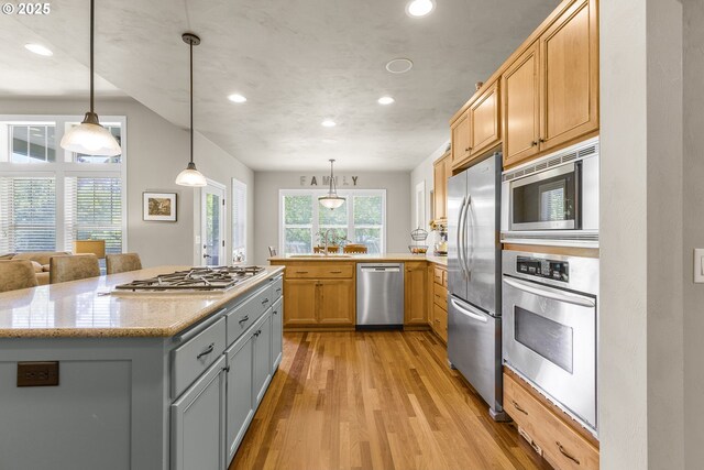 kitchen with a peninsula, recessed lighting, gray cabinets, light wood-style flooring, and stainless steel appliances