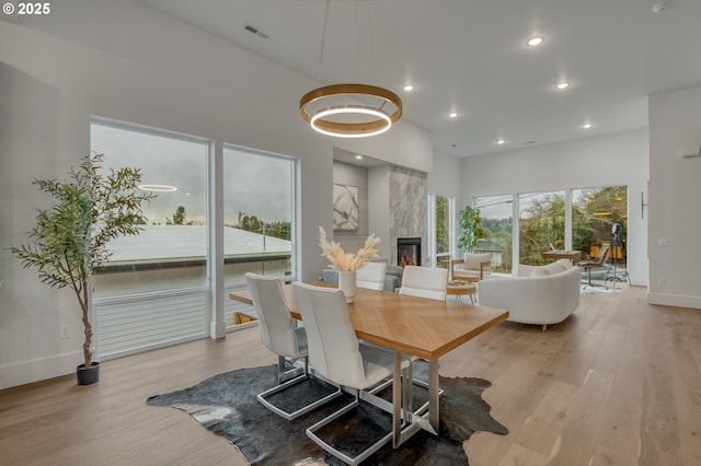 dining room with light hardwood / wood-style floors and a premium fireplace