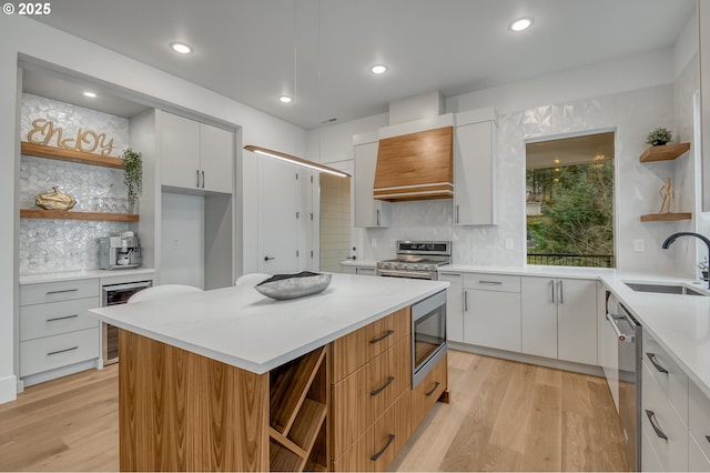 kitchen featuring decorative backsplash, white cabinetry, sink, and appliances with stainless steel finishes