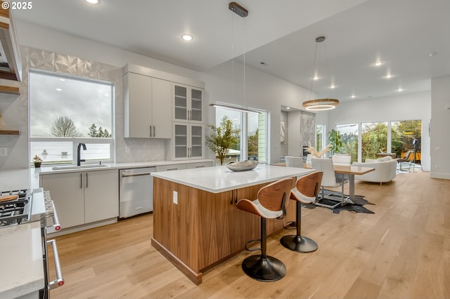 kitchen with stainless steel dishwasher, a center island, pendant lighting, and white cabinetry