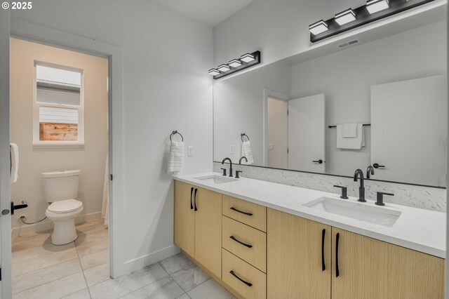 bathroom with tile patterned floors, vanity, and toilet