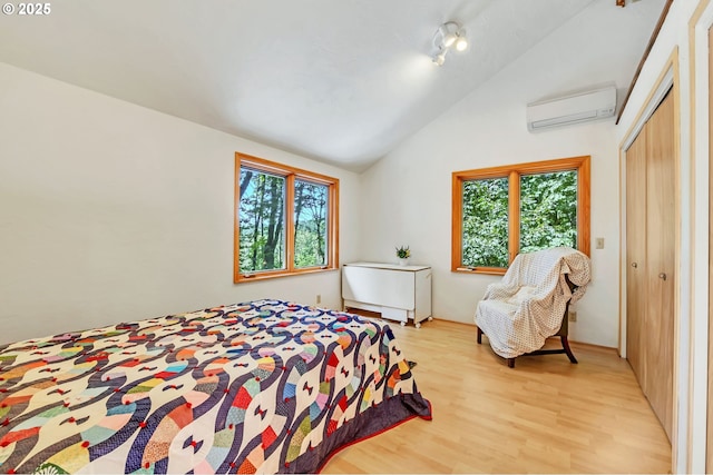 25498 Butler Rd, Junction City, OR 97448 - bedroom with an AC wall unit, multiple windows, lofted ceiling, light wood-type flooring, and a closet